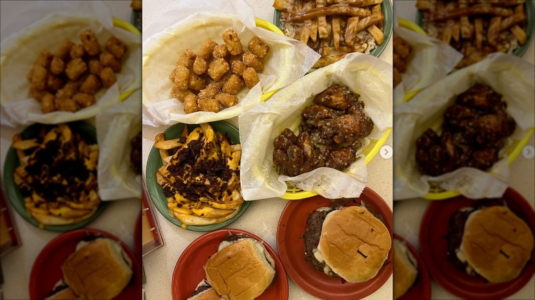 Burgers, fries, tots, and other sides in plastic baskets and on plates