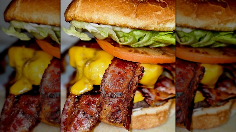 Burger with cheese, bacon, tomato, and lettuce