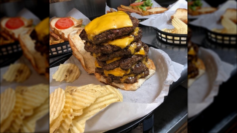 Cheeseburger with six patties on tray with potato chips