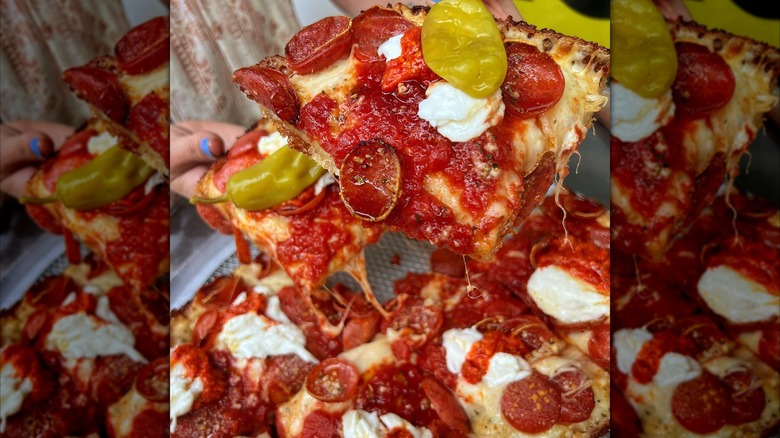 Hands picking up several pieces of pepperoni pizza