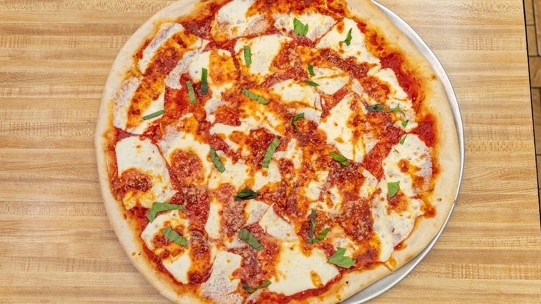 Margherita pizza on a wood-grain countertop