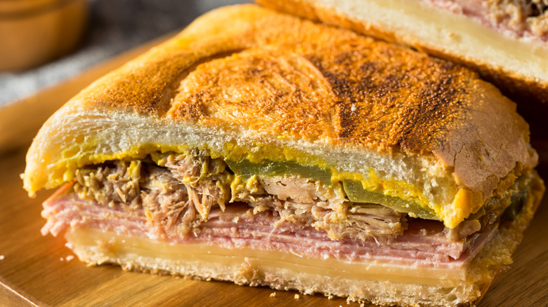 a Cubano sandwich cut in half on a wooden board