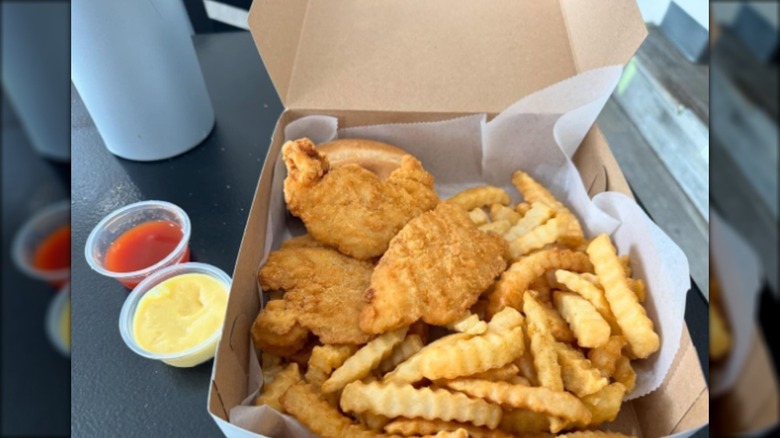 fried chicken and fries in cardboard takeout container