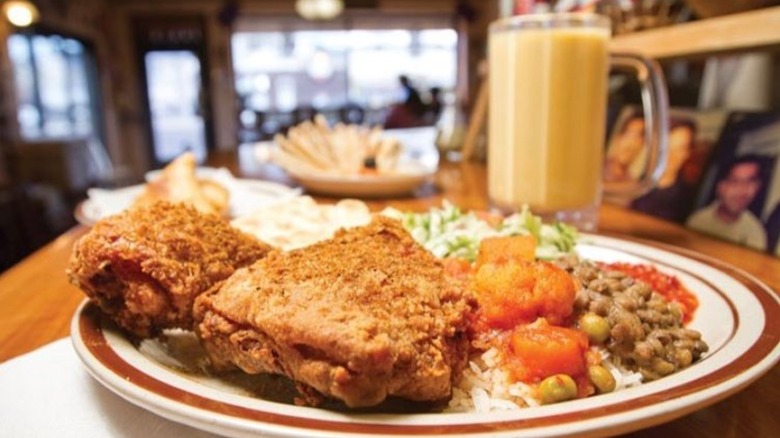 Curry fried chicken plate with rice and beans side