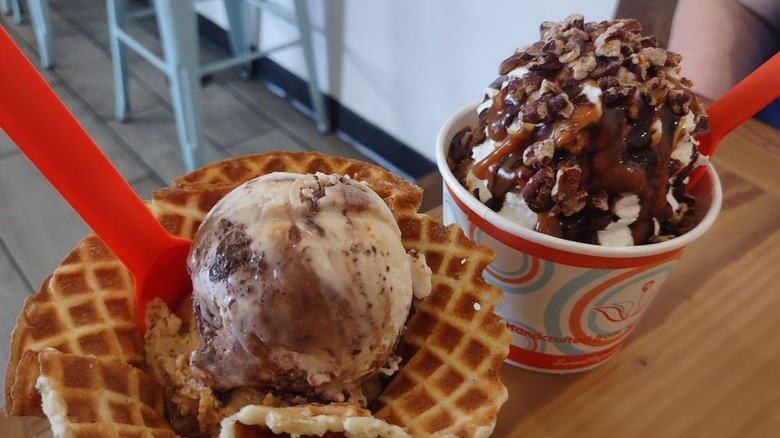 Pumpkin and brownie ice cream in waffle bowl alongside turtle sundae