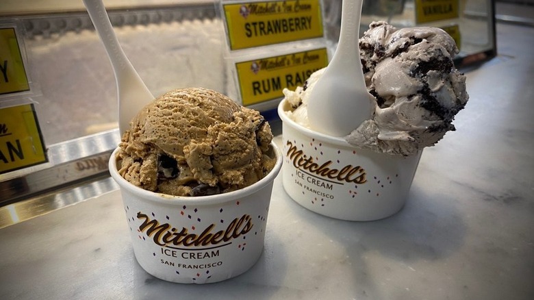 Two bowls of ice cream on counter in front of ice cream case