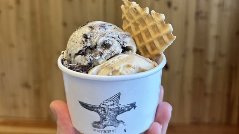 Two scoops of ice cream in cup with waffle cone triangle