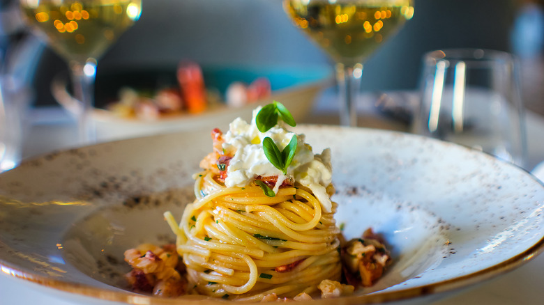 spaghetti with sauce and cheese plated fancily