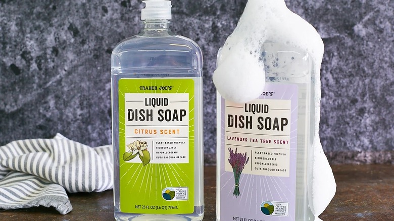 Trader Joe's Liquid Dish Soap in Lavender Tea Tree & Citrus scents displayed on a counter with soap suds
