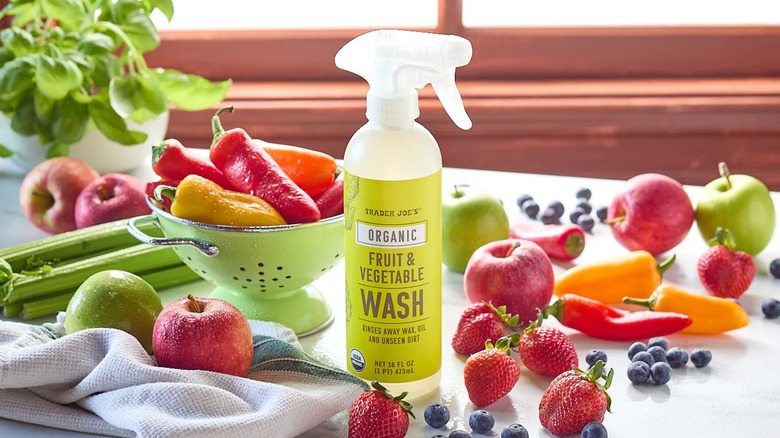 Trader Joe's Fruit & Vegetable Wash surrounded by fresh produce on a counter.