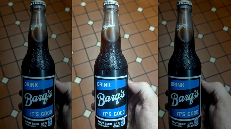Hand holding a bottle of Barq's Root Beer