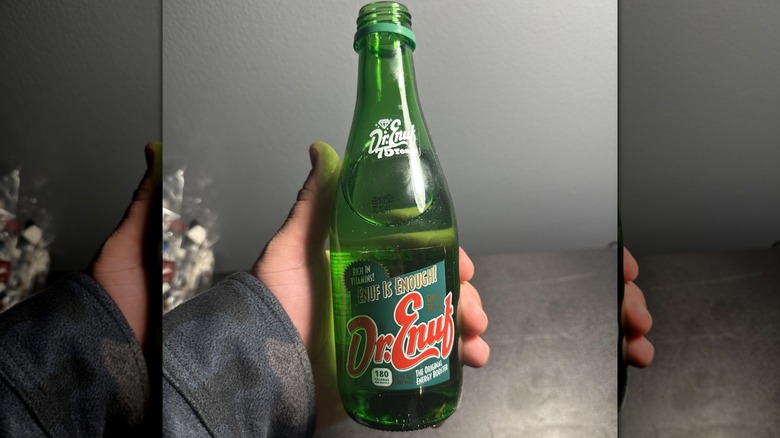 Hand holding a bottle of Dr. Enuf
