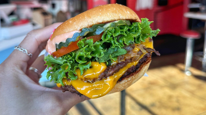 Hand holding a Monty's single cheeseburger