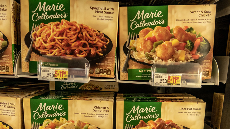 Frozen Marie Callender's meals sit on a shelf in a grocery store.