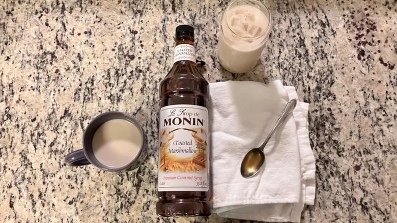 Monin Toasted Marshmallow syrup with mug, glass, towel, spoon