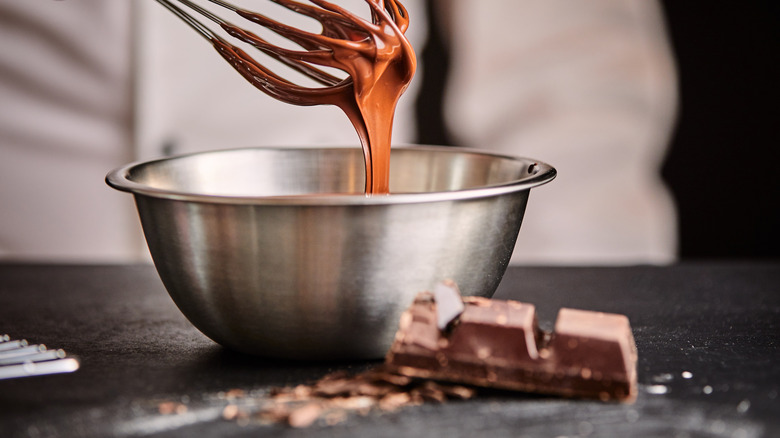 whisking chocolate in steel mixing bowl