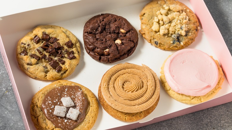 Open pink box with six Crumbl cookies inside