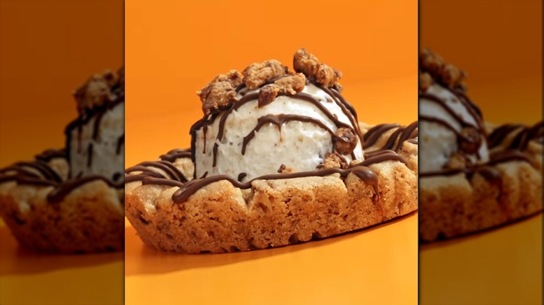 Crumbl Peanut Butter Cup Skillet Cookie on an orange background