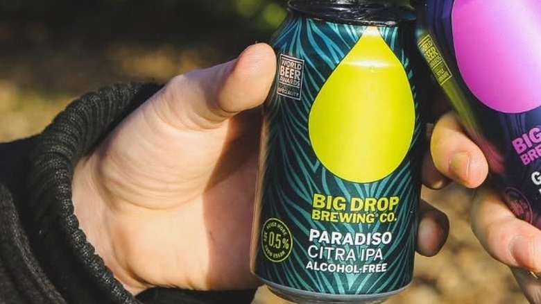 Man holding can of Big Drop Brewing Co. NA beer