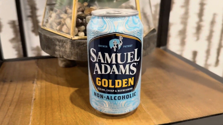 A Samuel Adams Golden NA beer on a wooden shelf