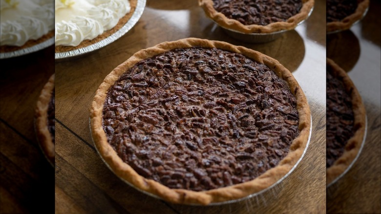 Whole pecan pie on wooden counter