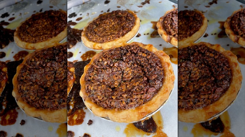 Two chocolate bourbon pecan pies on parchment paper