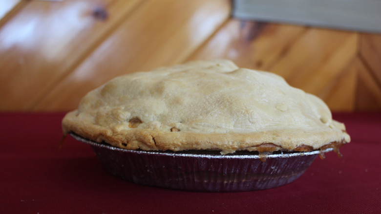 Close-up of a pie with upper crust on a dark red table