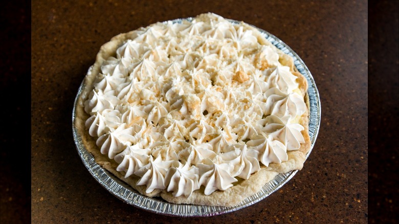Close-up of pie with dolloped cream topping on counter
