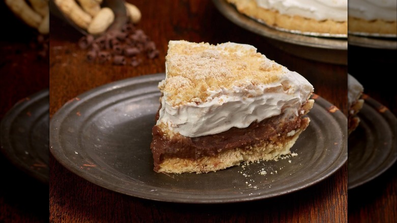 Close-up of chocolate pie with thick cream topping on stoneware plate