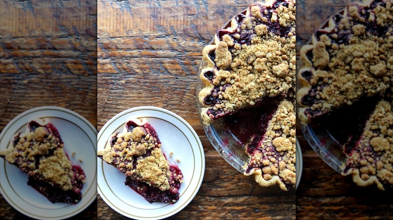 Top-down shot of fruit crumble pie slice on plate next to whole pie