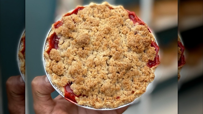 Hand holding mini crumble fruit pie