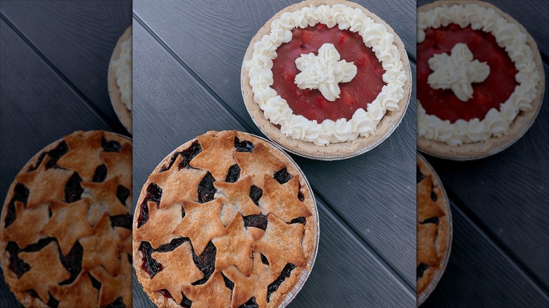 Top down of two fruit pies, one with star topping and one with whipped cream topping, on grey table