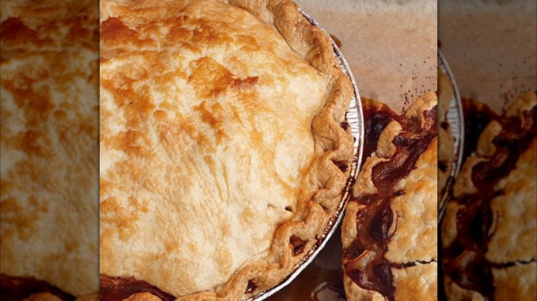 Close-up of pie with domed golden-brown top and crimped edges