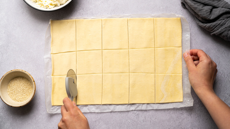 A tray of raw puff pastry cut into squares