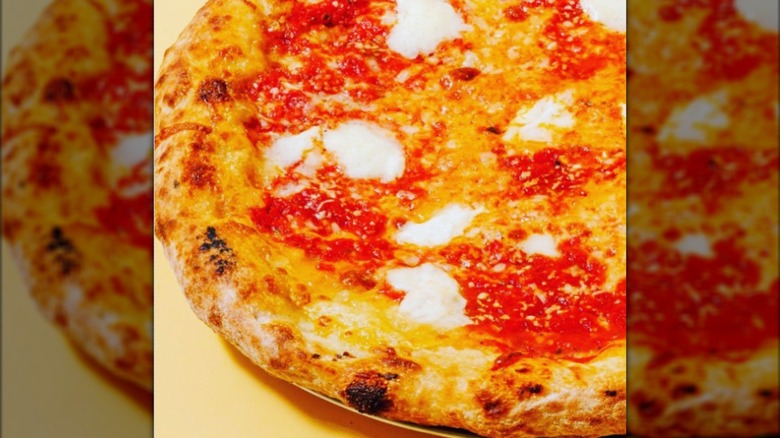 Close-up of pizza with sauce and mozzarella on tray