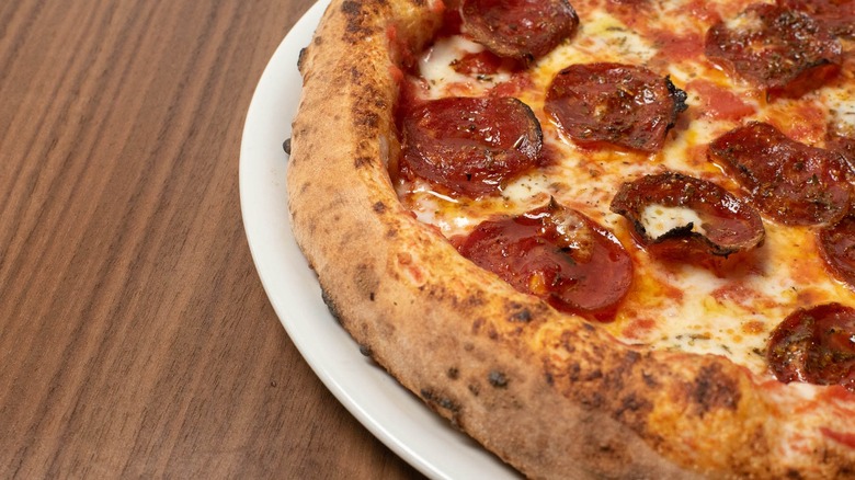 Close-up of pepperoni pizza on wood-grain table
