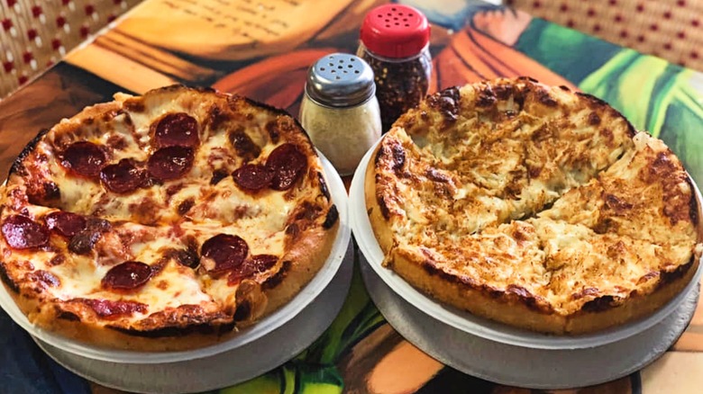 Two deep-dish pizzas on a colorful table