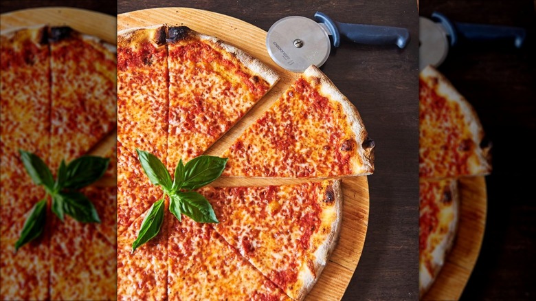 New York-style pizza cut in slices with pizza wheel