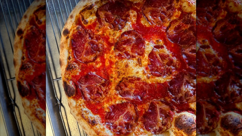Tomato sauce-heavy pizza on metal cooling rack