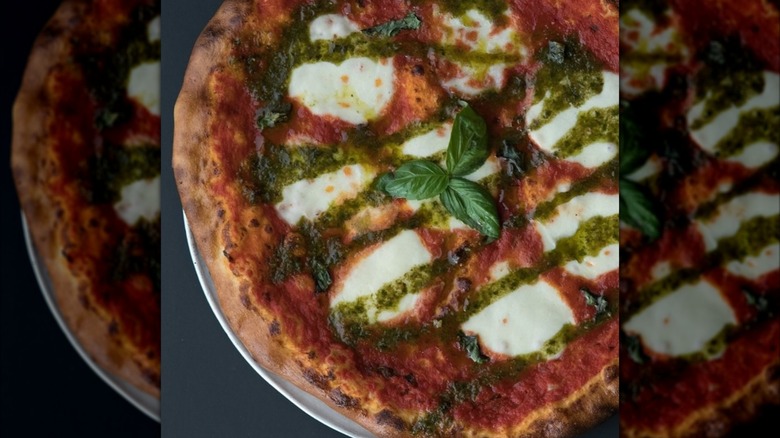 Coal-fired Margherita pizza with basil and pesto drizzle
