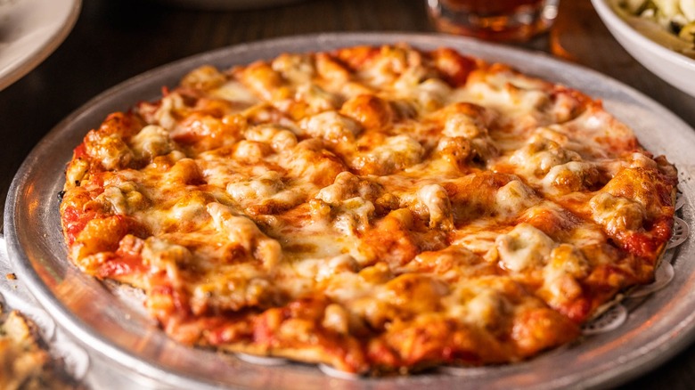 Thin-crust pizza on a silver tray