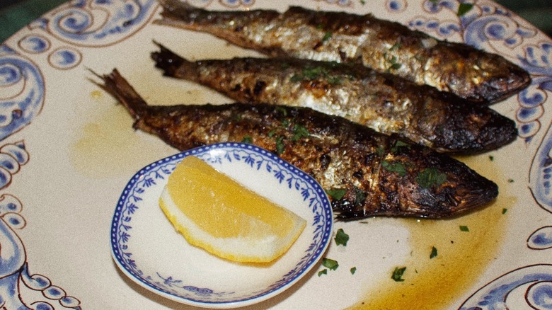 Grilled sardines with lemon wedge on china at Pike Place Market