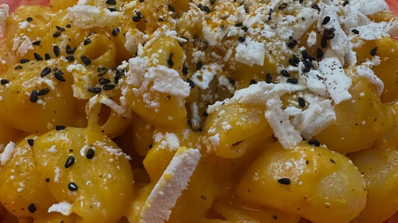 Up-close shot of carrot pasta at Pike Place Market with shaved cheese and seeds