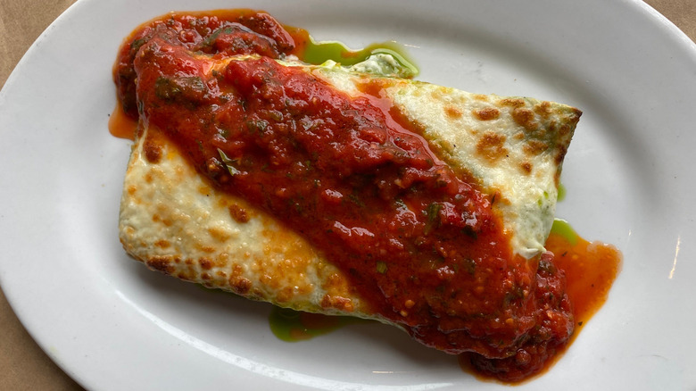 Pink Door lasagna on a white plate with marinara sauce in Pike Place Market