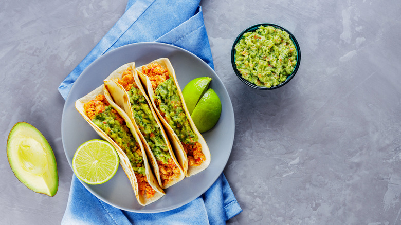tacos with lime and guacamole grey brackground
