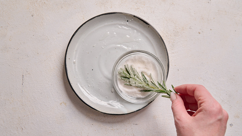 Pressing rosemary into sugar