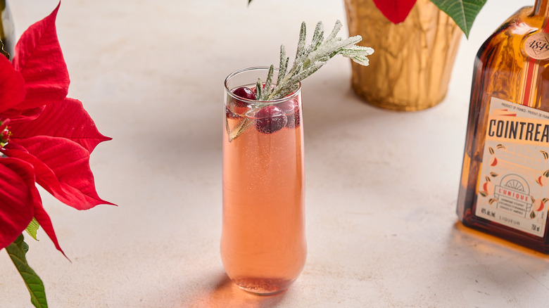 garnishing cocktail with cranberry and rosemary