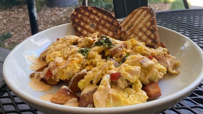 Breakfast bowl with toast, scrambled eggs, potatoes on table at Panini Pete's