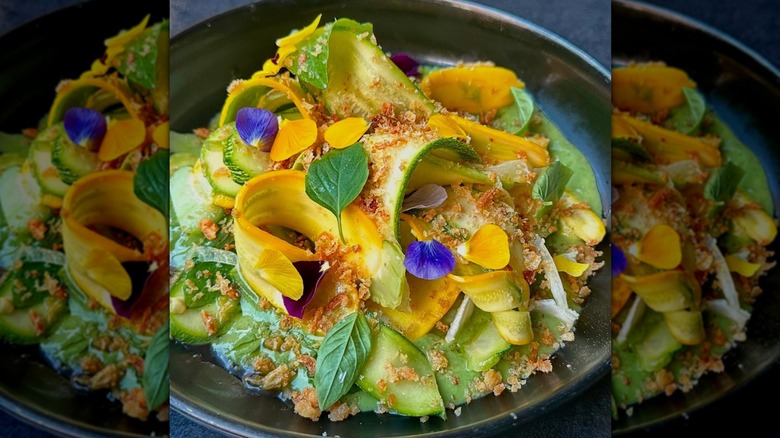 Bright salad with yellow shaved squash, greens, edible flower petals from In Bocca al Lupo, Alaska