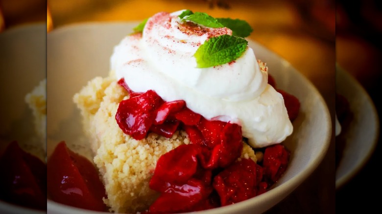 Close-up of strawberry shortcake with whipped cream garnished with mint at The Root Cafe